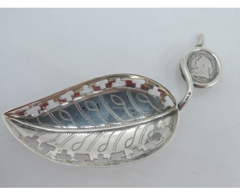 An Edwardian silver caddy spoon modelled as a leaf with pierced borders and stalk handle wound round a small Victorian silver