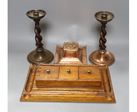 A copper Arts &amp; Crafts inkwell, a pair of A Jones turned candlesticks and an early 20th century oak ink stand (4)