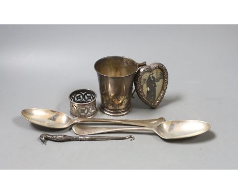 Two 18th century silver spoons, a later silver christening mug, small silver mounted heart shaped photograph frame, a silver 