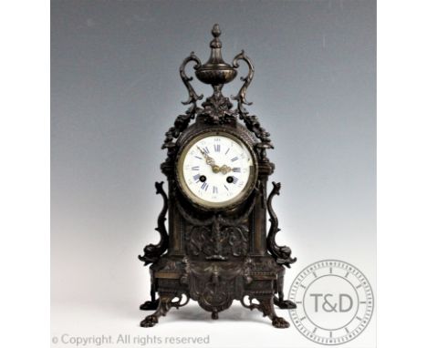 A late 19th century French bronzed mantel clock, the elaborate dome case with urn surmount and floral details and vines, each