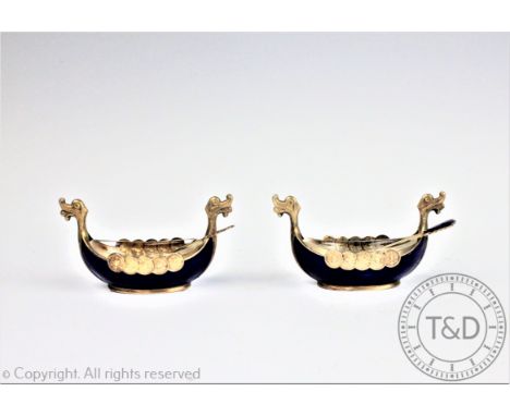 A pair of Norwegian silver and enamel salts each modelled as a Viking ship, each silver gilt salt enamelled in blue the exter