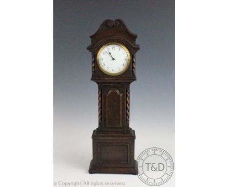 A 1920's oak mantel time piece modelled as a longcase clock, with Roman numeral enamel dial, 47cm high