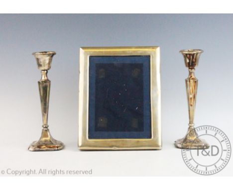 A pair of George V silver candlesticks, Birmingham 1912, 21cm high with a rectangular silver mounted photograph frame, 22.5cm