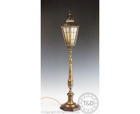 A brass table lamp modelled as a street lamp, with an early 20th century embossed brass lantern top with crown surmount, on a