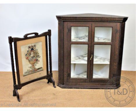 A 19th century oak hanging corner cabinet, with glazed doors, 108cm H x 101cm W, with an oak fire screen inset with a tapestr