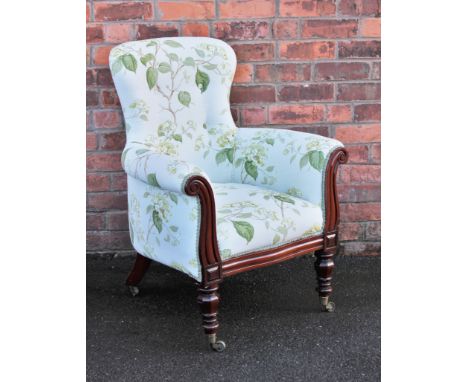 A William IV mahogany library chair, with later button back floral upholstery, with scroll fronted arms, on turned octagonal 