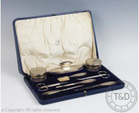 A late Victorian silver nine piece manicure set, Birmingham, 1900, with engine turned detailing and steel scissors, in fitted