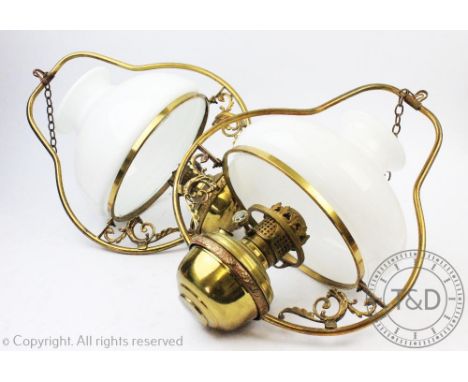 Four early 20th century brass ceiling oil lights, converted for electricity, one with a green glass reservoir, all with opaqu