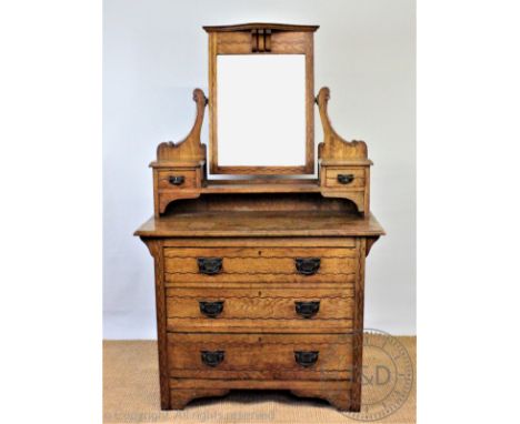 An Edwardian Art Nouveau inlaid oak dressing table, with mirror and two drawers above three graduated long drawers, on bracke