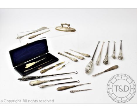 A selection of Victorian and later silver handled button hooks, longest 30cm, with a silver manicure set, silver handled shoe