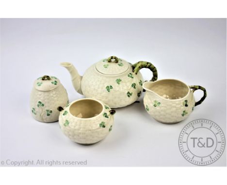 A Belleek four piece part tea service, comprising teapot and cover, sugar bowl, milk jug and a jar and cover, decorated with 
