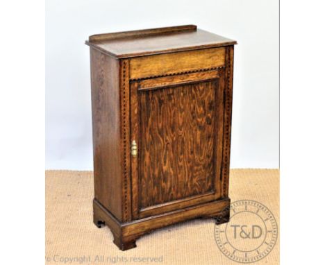 An Edwardian inlaid oak cupboard, with panelled door, on bracket feet, 85cm H x 57cm W x 31cm D, with an oak mirror and an ir