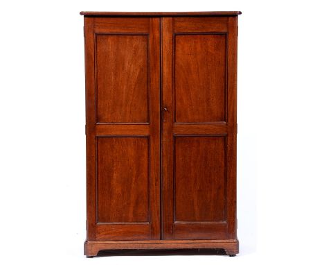 A Victorian mahogany cabinet, c1870, the rounded rectangular top with moulded lip above a pair of twin panelled doors reveali