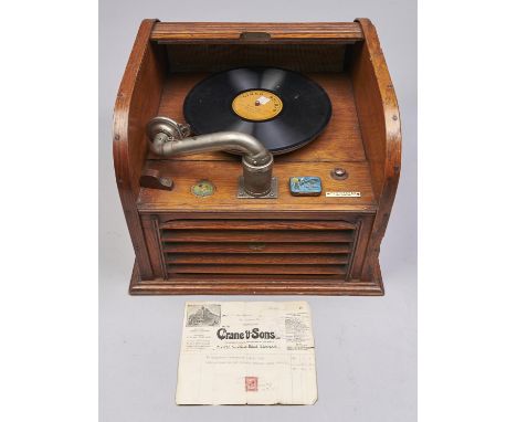 A Conqueror Pathephone table gramophone, 1917, in light oak with tambour top, maker's athlete trademark transfer and ivorine 