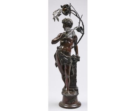 A bronzed electroformed metal figural lamp, in the form of a youth with panpipes and naked save for a boars pelt, standing by