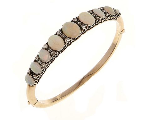 An opal and diamond bangle, early 20th c, in gold, 56mm (internal), unmarked, 12.5g Two of the larger opals slightly scratche