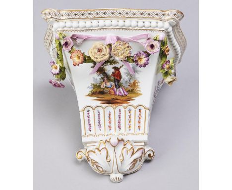 A German floral encrusted porcelain wall bracket, c1900, painted with rustic lovers, loose bouquets and applied with festoons