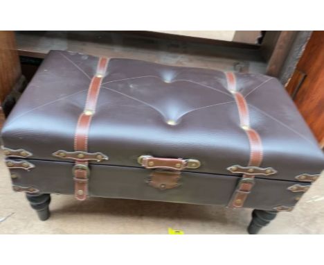 A brown leatherette hinged trunk coffee table on turned legs