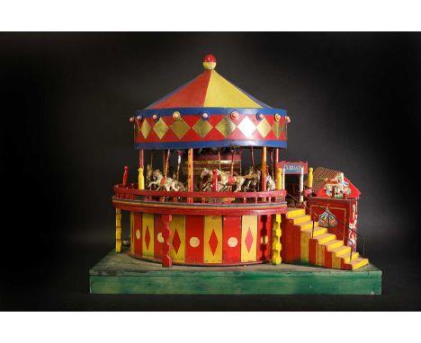 A scratch-built model of a carousel, 20th century, decorated in polychrome and with later application of stickers, the centra