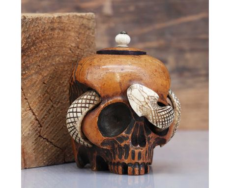 A carved fruitwood vanitas inkwell,19th century, Continental, modelled as a skull, surmounted by a carved bone snake, glass l