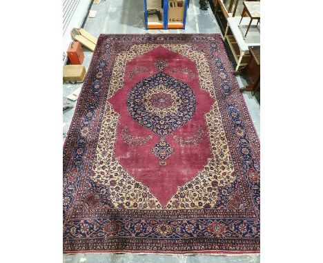 Persian-style carpet having shaped oval floral central medallion to the maroon ground, cream spandrels with herati border and