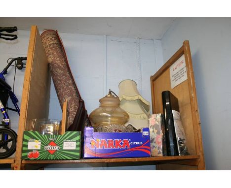 A shelf of miscellaneous, lampshades, rug etc.