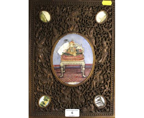 A 19th Century Indian carved wooden panel, inset with paintings of various buildings and a figure