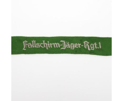 A machine embroidered cuff title 'Fallschirm Jager Rgt 1' against a green felt type backing, with folded and sewn edges, 46cm