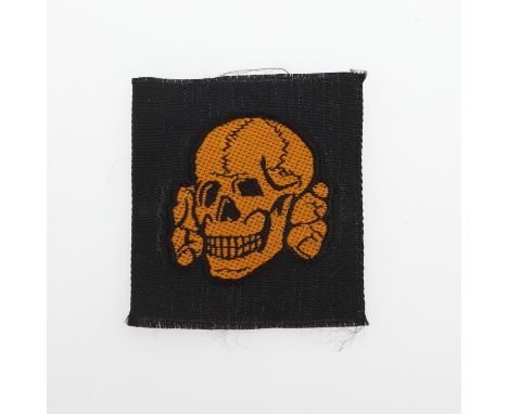 A pale brown Waffen SS BeVo type skull and crossed bones badge in pale brown against black as for the summer ski cap. Cut fro