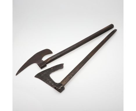 An axe head with sharpened blade with pointed top and rounded base, on a stained wooden shaft, the head 35 x 20cm, the shaft 