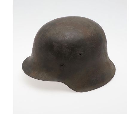A Second World War or later finished M42 type steel helmet shell, with worn dark painted finish and no decals. The helmet wit