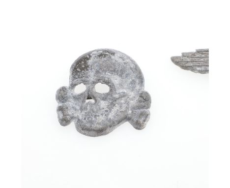 A cap insignia set comprising zinc eagle and second type skull with brass fixing pins to the rear. With RZM and other obscure
