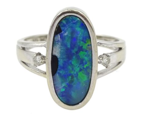 14ct white gold oval opal duplet ring, with a single diamond set either side, stamped 585