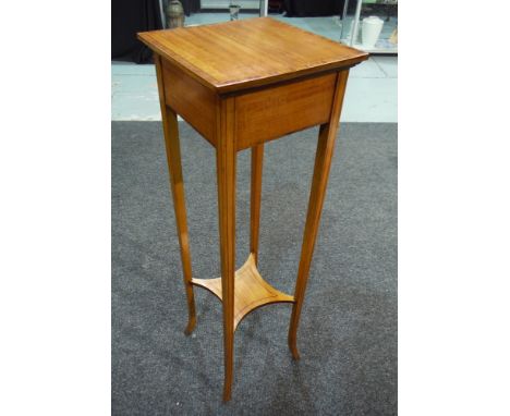 A satinwood jardiniere stand or torchere of square form, with walnut cross banded borders, the tapered legs united by a stret