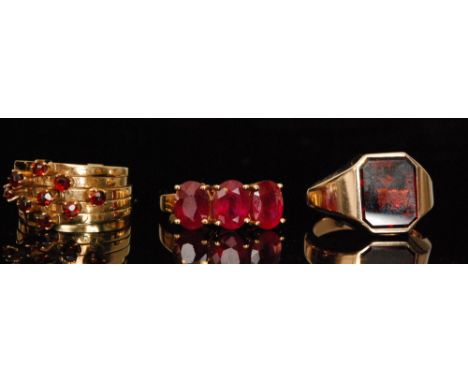 A modern 9ct garnet set signet ring, a 9ct five band garnet ring and a 9ct three stone synthetic ruby ring (3)  