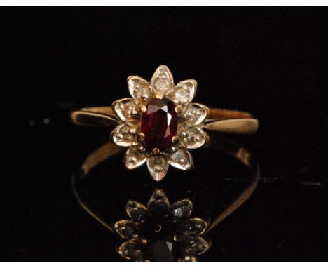 A hallmarked 9ct ruby and diamond cluster ring, oval cut ruby with diamond surround, knife edge shoulder, weight 1.8g, ring s