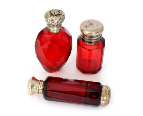 A Victorian gilt metal mounted ruby glass double ended scent bottle, the slice cut bottle with hinged cap and ruby glass stop