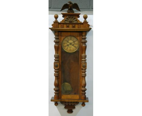 A late 19th to early 20th Century walnut Vienna style wall clock, spring driven movement, the cornice with moulded eagle fini