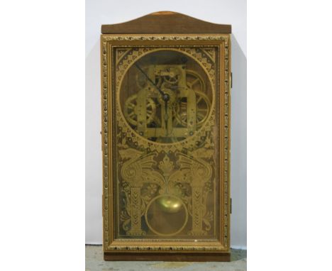 An American St Thomas skeleton wall mounted alarm clock striking on a bell enclosed by a stencilled gilt glazed panelled door