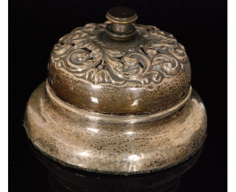 An early 20th Century hallmarked silver desk bell with embossed foliate decoration surround central bell button, diameter 9.5