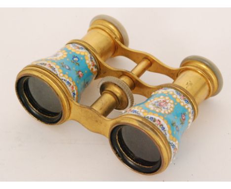 A pair of French gilt metal, enamel and mother of pearl opera glasses decorated with gilded floral vigneettes to a pale blue 
