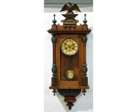 A late 19th to early 20th Century walnut Vienna style wall clock, spring driven movement, the cornice with turned finials and