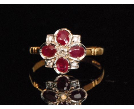 An 18ct hallmarked ruby and diamond cluster ring, central diamond with four radiating oval rubies spaced by diamonds, ring si