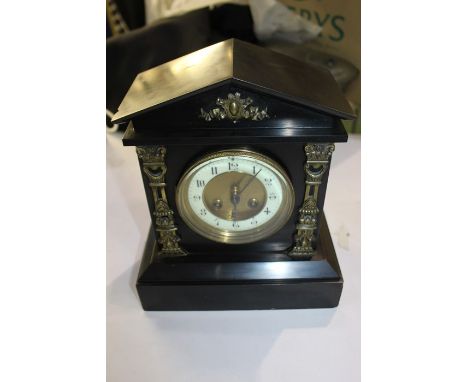 Black slate mantel clock, with an arched top above the dial