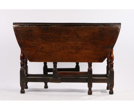 18th Century oak drop-leaf gate leg table, the leaves reduced in length, with frieze drawer, on turned legs and flattened str