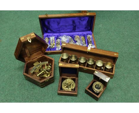 Brass sextant, map magnifier, compass and set of six tot cups, all housed in teak cases with brass inlaid anchors