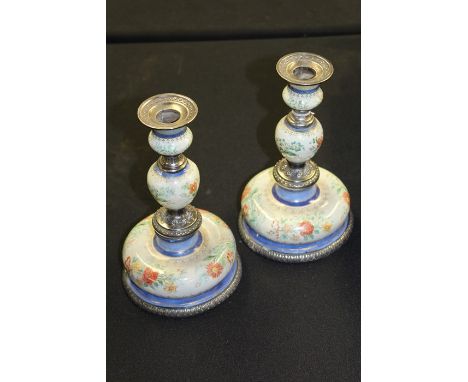 Pair of 19th Century white metal and enamel candlesticks, with beaded sconces above foliate enamel and white metal central co