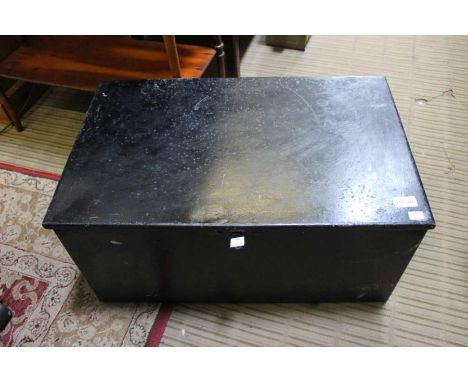 A black metal trunk, hinged lid with lock and key, fitted side carrying handles