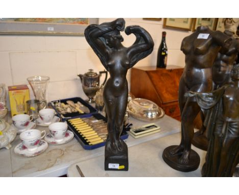 A bronzed Art Deco figurine in the form of a nude female, bearing signature