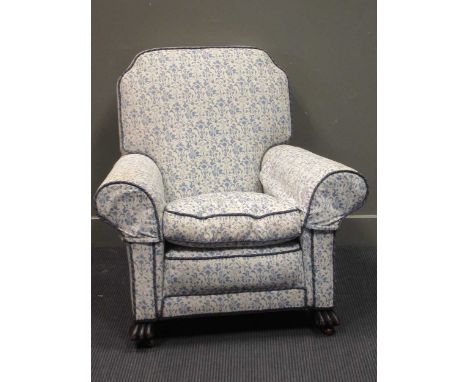 Circa 1900 a scroll arm armchair on carved feet and ceramic castors